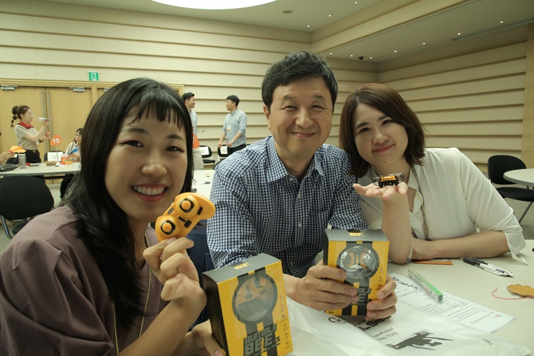 CJ CGV '리버스 멘토링' 현장에서 참가자들이 범블비 피규어를 들고 포즈를 잡고 있다