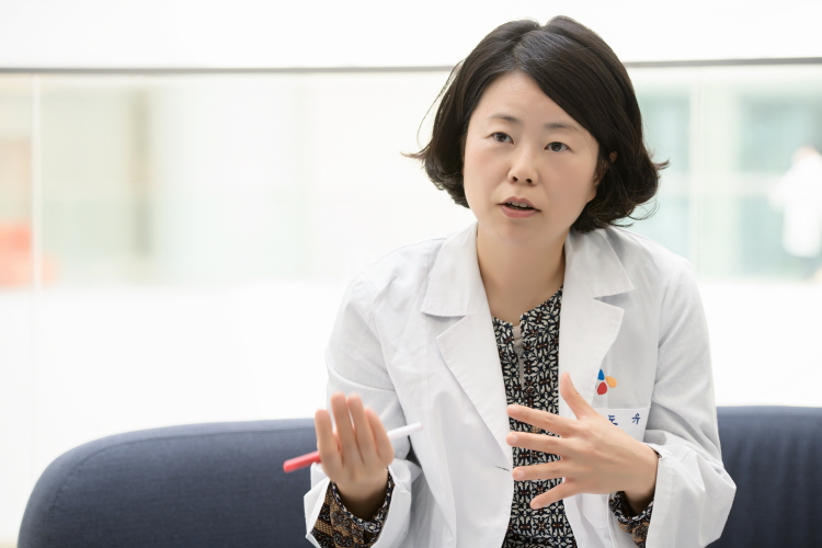 CJ제일제당 연구소인 블러썸파크 식품연구소 로비 소파에 앉은 성도유 수석연구원이 펜을 들고 흑삼에 대한 이야기를 나누고 있다.