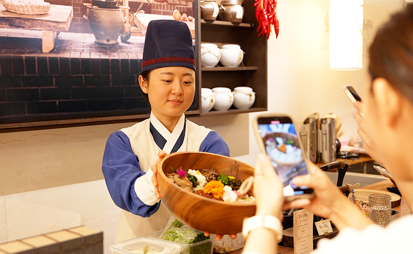 폭군의 셰프X퀴진케이 팝업 다이닝 이벤트 현장에서 고객들이 제공된 요리 사진을 찍는 모습
