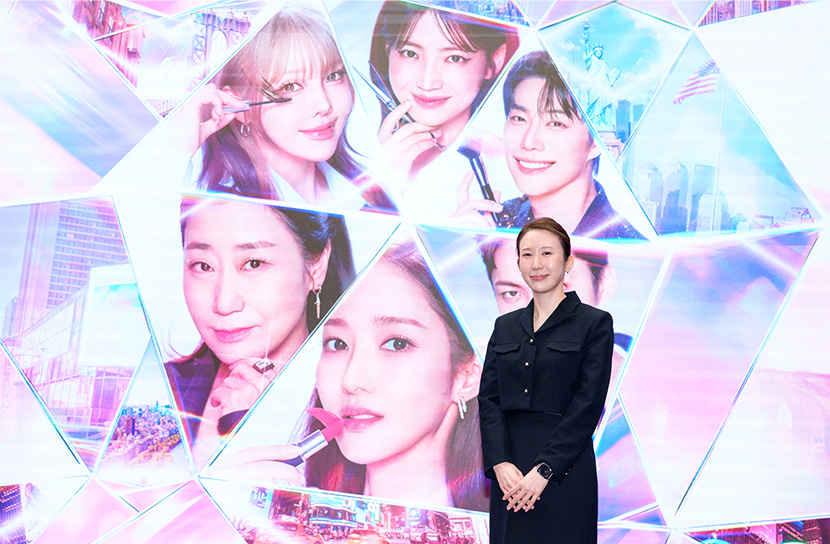 '트렌드 코리아' 공동 저자인 서유현 박사가 <퍼펙트 글로우> 메인 포스터가 띄워진 화면 앞에서 포즈를 취하고 있다.