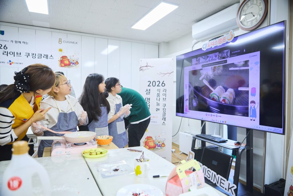 지난 11일 서울 마포구에 위치한 망원무지개지역아동센터에서 CJ그룹 임직원 및 퀴진케이 셰프들이 아동들의 라이브 쿠킹클래스 참여를 돕고 있다.