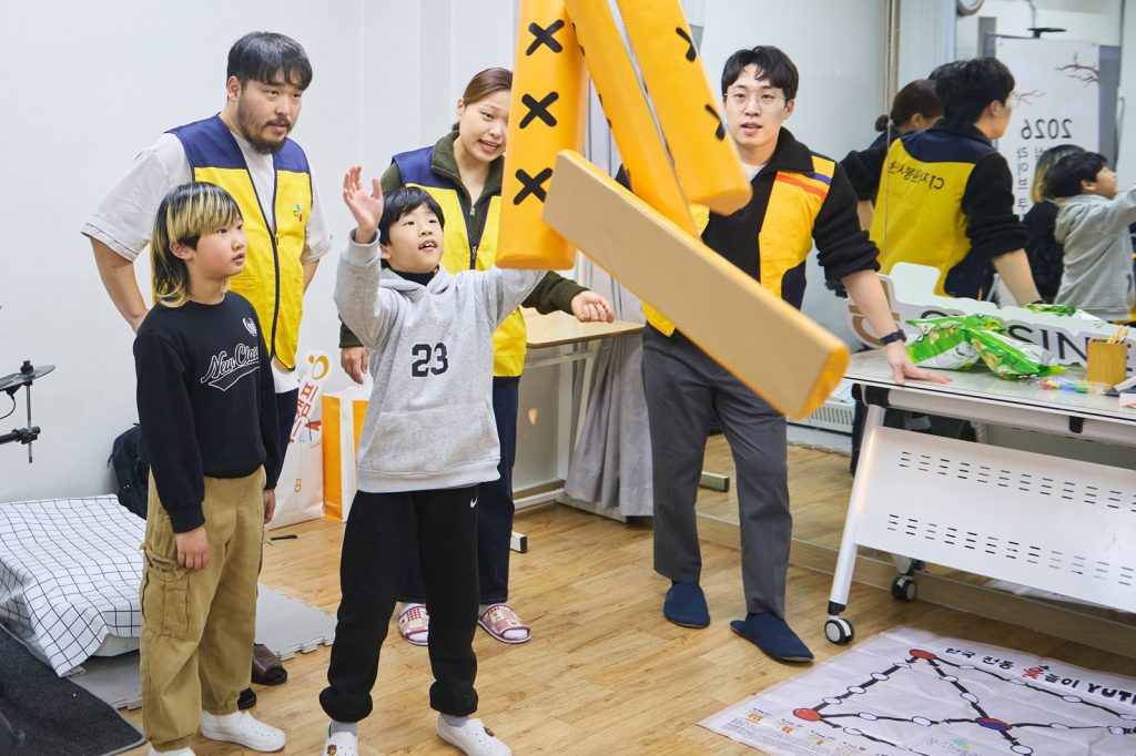 지난 11일 서울 마포구에 위치한 망원무지개지역아동센터에서 CJ그룹 임직원 및 퀴진케이 셰프들과 아동들이 윷놀이를 즐기고 있다.