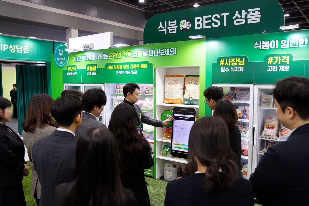 18일 오전 서울 양재 aT 센터에서 개최된 '푸드 솔루션 페어 2026'을 찾은 관람객들이 온라인 식자재 유통 플랫폼 '식봄'에 대한 설명을 듣고 있다.