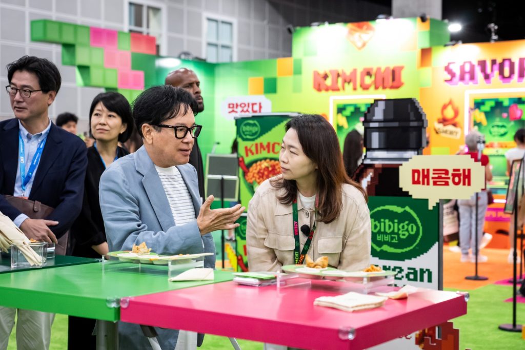 KCON LA 2026을 방문한 CJ 이재현 회장이 비비고 부스에서 미니완탕과 김치 라면을 맛보고 있다.