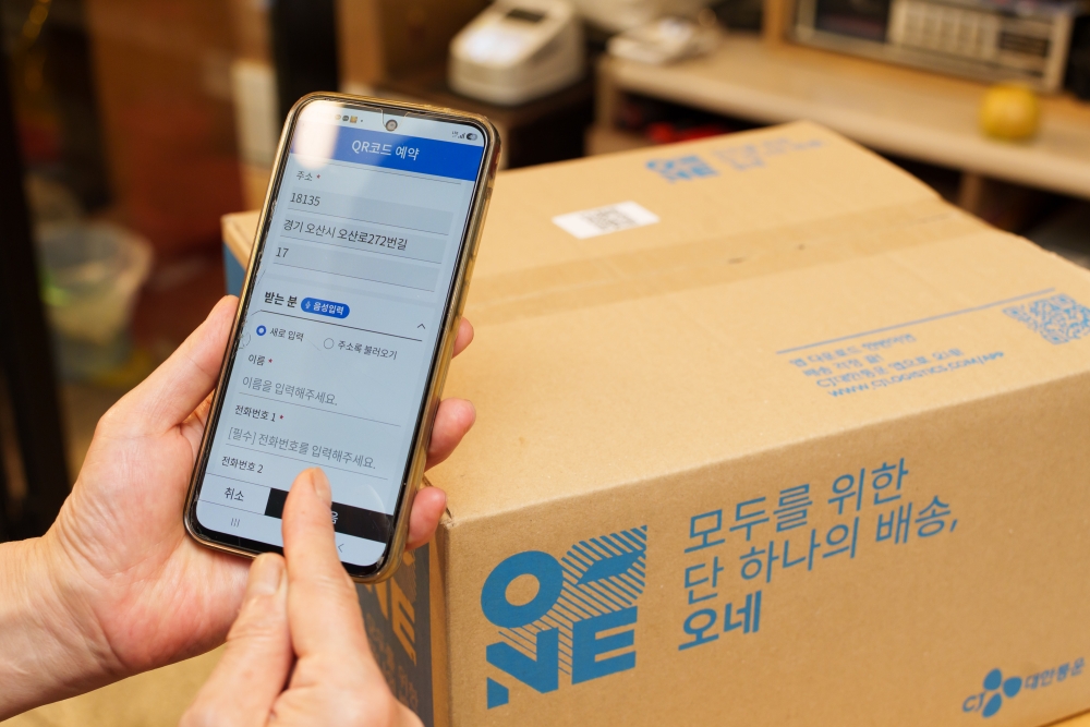 오산 오색시장 상인이 '오네' 앱에서 QR코드를 활용해 택배 배송 접수를 하고 있다.