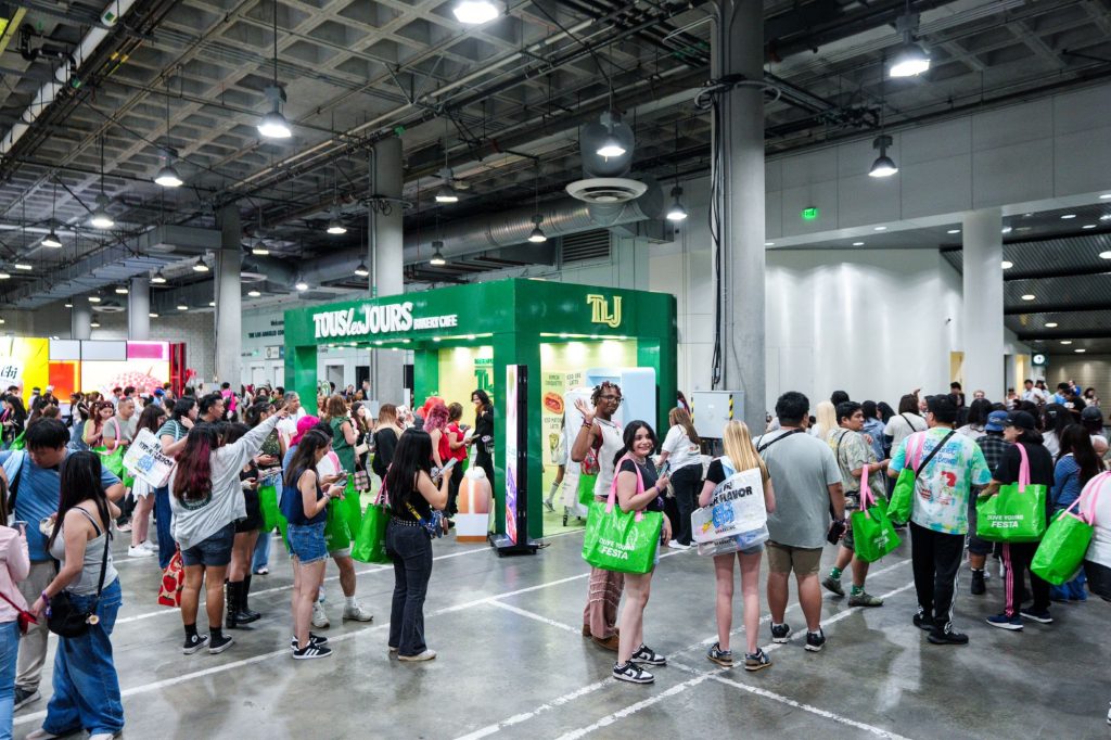 KCON LA 2026 방문객들이 현지시간으로 15일 CJ올리브영 타포린백을 메고 CJ푸드빌의 뚜레쥬르 이벤트를 참여하기 위해 줄을 서있다